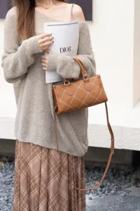 Stylish brown leather shoulder pillow bag with contrast white stitching for women daily use.