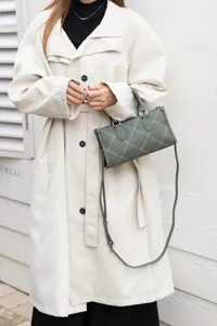 Dark green pillow shoulder bag with contrast stitching, chic minimalist crossbody bag for women.