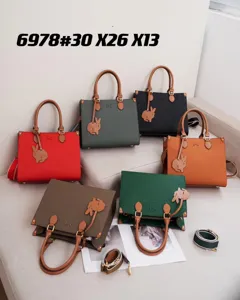 Vista dettagliata della grande borsa tote da donna in vera pelle con ciondolo a forma di coniglio.