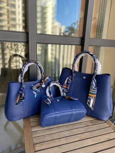 Set di borse tote da giardino in pelle bovina blu con manici decorati da sciarpa.