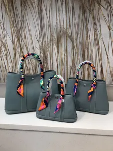 Borsa shopper in vera pelle grigia con foulard colorati, dettagli borsa a spalla elegante.
