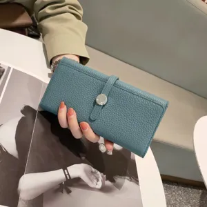 Detail view of the teal genuine leather long wallet featuring a snap closure and chic strap.