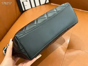 Detailed view of black quilted leather handbag bottom structure, premium texture and stitching.