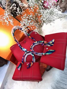 Set borsa shopper in pelle rossa con dettaglio di foulard in seta floreale elegante.