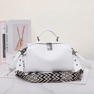 Borsa a mano in pelle bianca con ampia tracolla geometrica e design elegante.