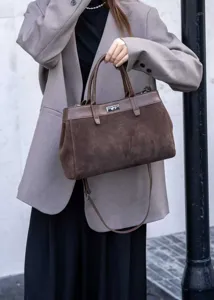 Suede contrast color top handle tote bag with metal turn-lock closure, detailed view.