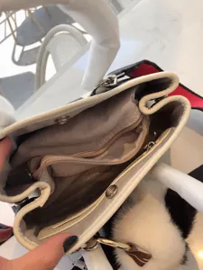 Dettaglio interno della borsa elegante con fodera in tessuto e scomparti con cerniera.