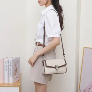 Élégant sac à bandoulière pour femme avec fermoir tournant chic et finitions contrastées.