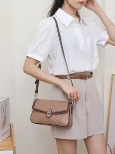 Sac à bandoulière chic pour femme avec rabat et fermeture métallique élégante.
