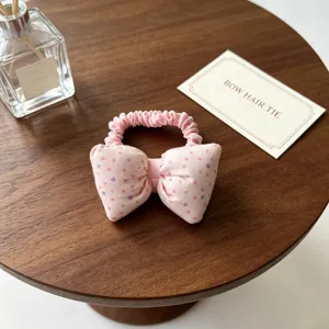 Détail d'élastique à cheveux nœud à pois rose, joli bandeau en tissu pour coiffure enfant.