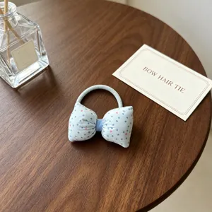 Vue détaillée du joli élastique à cheveux à nœud bleu à pois avec une haute élasticité.