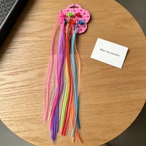 Colorful children wig hair extensions with mini claw clips on floral card detail view