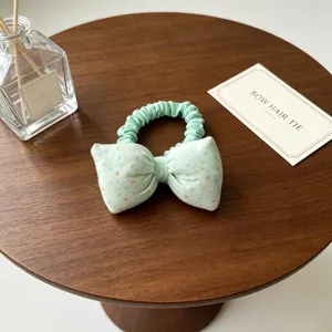 Joli chouchou en tissu vert menthe avec nœud à pois pour les enfants et les filles.