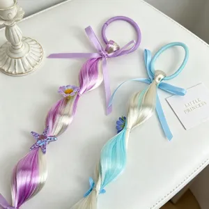 Detailaufnahme von süßen Kinder Haarverlängerung Zopf Haargummis mit Schleifen und Seestern.