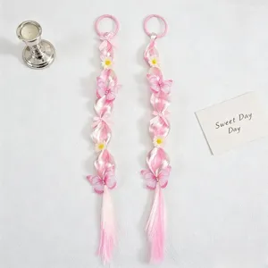 Detail view of pink gradient hair extension braid decorated with butterflies and flowers.