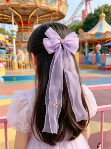 Detailansicht einer lila Mesh Haarschleife mit Blumenstickerei und eleganter Zopfspange.