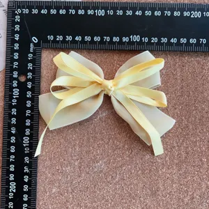 Detailed close-up of a sweet yellow ribbon hair bow with long tails and delicate fabric.