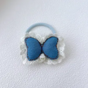 Gros plan détaillé d'un élastique à cheveux papillon en jean bleu avec une bordure en dentelle.