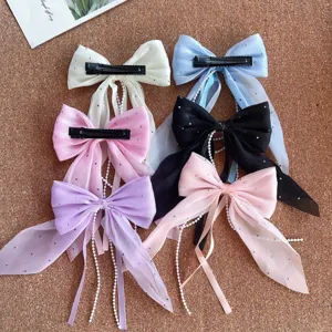 Close up detail of colorful bow hair clips with artificial pearls and sweet ribbon design.