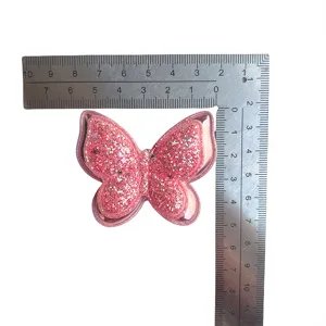 Nahaufnahme von rosa Glitzer Schmetterling Haarspange, funkelndes DIY Accessoire für Mädchen.