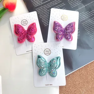 Nahaufnahme Detail von doppelseitigen Glitzer Schmetterling Haarspangen auf Pappkarten.