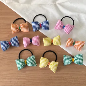 Vue détaillée en gros plan d'élastiques et pinces à cheveux à carreaux colorés, style mignon.