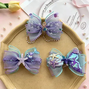Detailed view of sparkly mermaid bow hair clips with pearls and cute starfish charms.