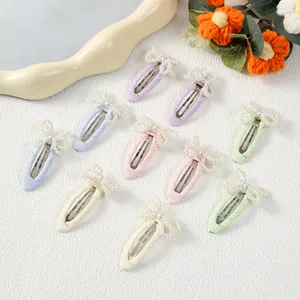 Primer plano de clips para el cabello con lazo de perlas, colores pastel, accesorios.