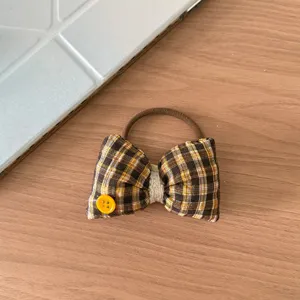 Dettaglio elastico per capelli con fiocco scozzese marrone, graziosa corda in tessuto.