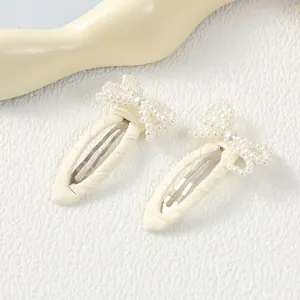 Primer plano detallado de lindo pasador de pelo con lazo de perlas diseño blanco diario.