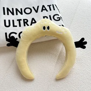 Gros plan détaillé du joli serre-tête en peluche jaune avec visage brodé et mains drôles.