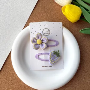 Adorables pinces à cheveux en tissu violet fait main avec de jolis motifs de fleurs et de fraises.