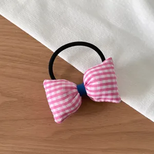Vue détaillée chouchou nœud vichy rose, accessoire cheveux en tissu mignon pour queues.
