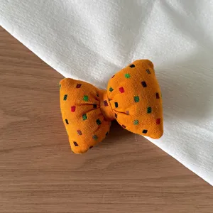 Korean style orange fabric bow hair accessory detail shot, colorful square print.