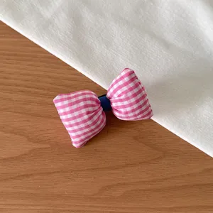 Gros plan d'un joli chouchou en tissu à carreaux roses, parfait pour coiffer vos cheveux.