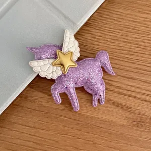 Glitter purple unicorn hair clip detail, angel wings and gold star ornament, cute DIY accessory.
