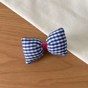 Vue détaillée d'un joli élastique à cheveux nœud vichy bleu et blanc, accessoire tissu.