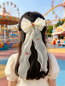 Detailansicht der eleganten weißen Mesh-Schleife Haarspange mit Blumenstickerei und Bändern.