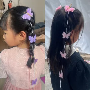 Gros plan de pinces à cheveux papillon pour enfants avec chaînes de perles pour tresses.