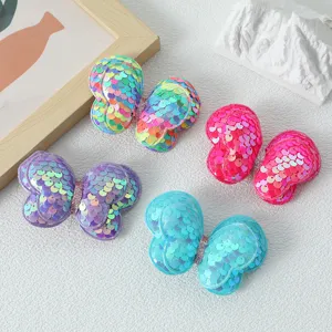 Primo piano di graziosi fermagli per capelli con farfalla di paillettes per bambini.