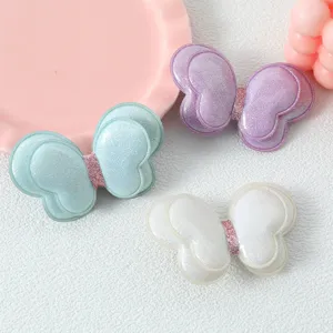 Vue détaillée d'accessoires de cheveux papillon doubles scintillants et breloques DIY.
