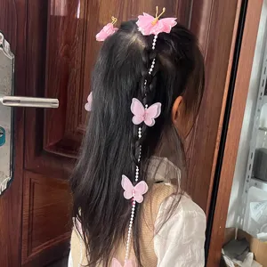 Vue détaillée de pinces papillon rose faites main avec des chaînes de perles pour tresses.