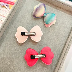 Primo piano dettagliato di mollette per capelli con fiocco scintillante colorato, tessuto glitterato.
