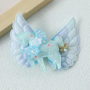 Glitter unicorn angel wings hair clip detail, sparkly blue cute kids hair accessory closeup