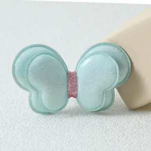 Gros plan détaillé d'un accessoire de pince à cheveux papillon double couche bleu clair.
