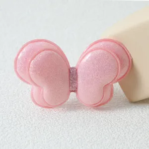 Vue détaillée de la pince à cheveux papillon double à paillettes roses pour coiffures mignonnes.