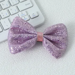 Vue détail de pince à cheveux nœud pailleté violet, accessoire cheveux à sequins brillants.