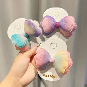 Dettaglio di fermaglio per capelli con doppio fiocco sfumato e brillanti colori.