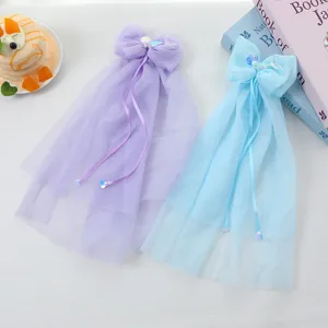 Vista detallada de la pinza para el pelo con lazo de tul y cola de sirena para niñas pequeñas.