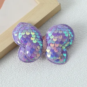 Primo piano dell'accessorio per capelli con fiocco di paillettes viola, design brillante.